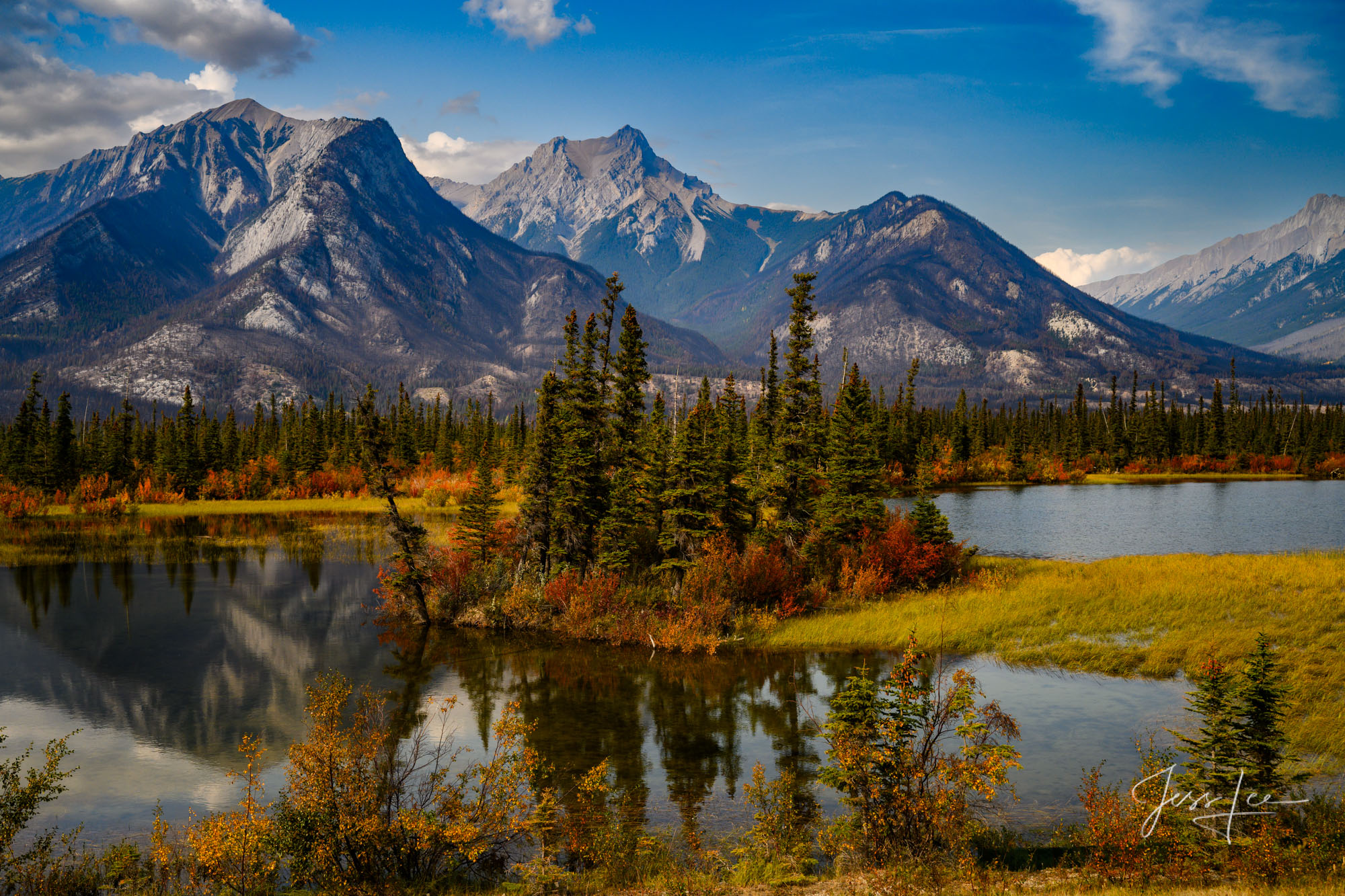 A tranquil view of a turquoise lake in the Canadian Rockies, representing scenic touring.